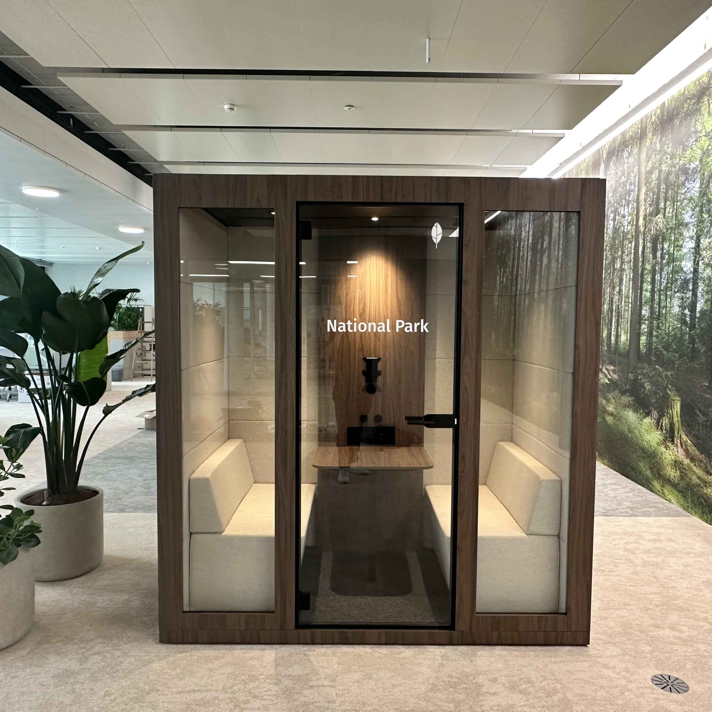 Silent Room M Besprechungsbox in Holzoptik mit Glasfront und gepolsterten Sitzbaenken – stilvolle Raum-in-Raum Loesung fuer vertrauliche Meetings und konzentrierte Teamarbeit im Buero