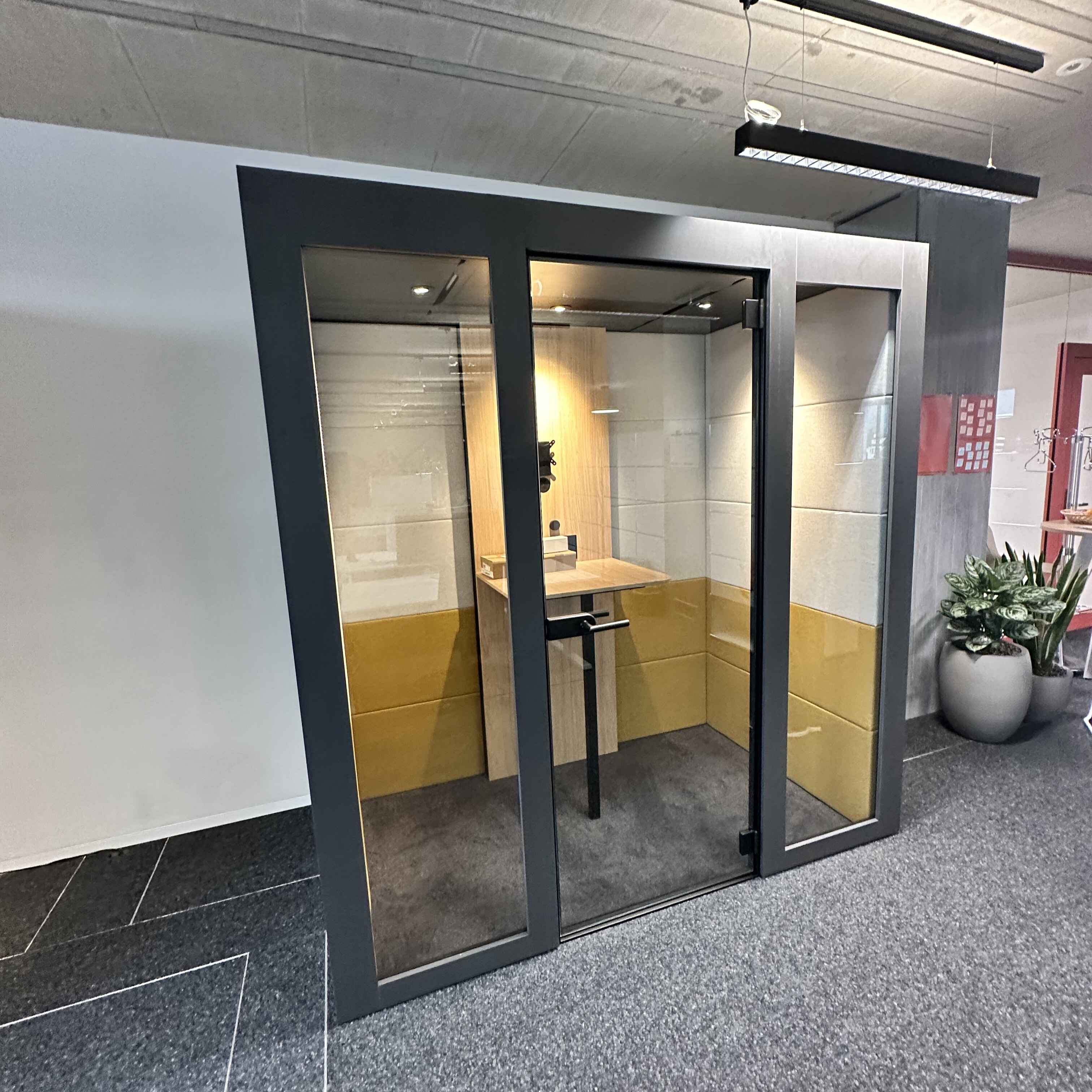 Silent Room M Besprechungsbox mit Glasfront, gepolsterten Sitzbaenken und Tisch – moderne Raum-in-Raum Loesung fuer effiziente Besprechungen in offener Bueroarchitektur