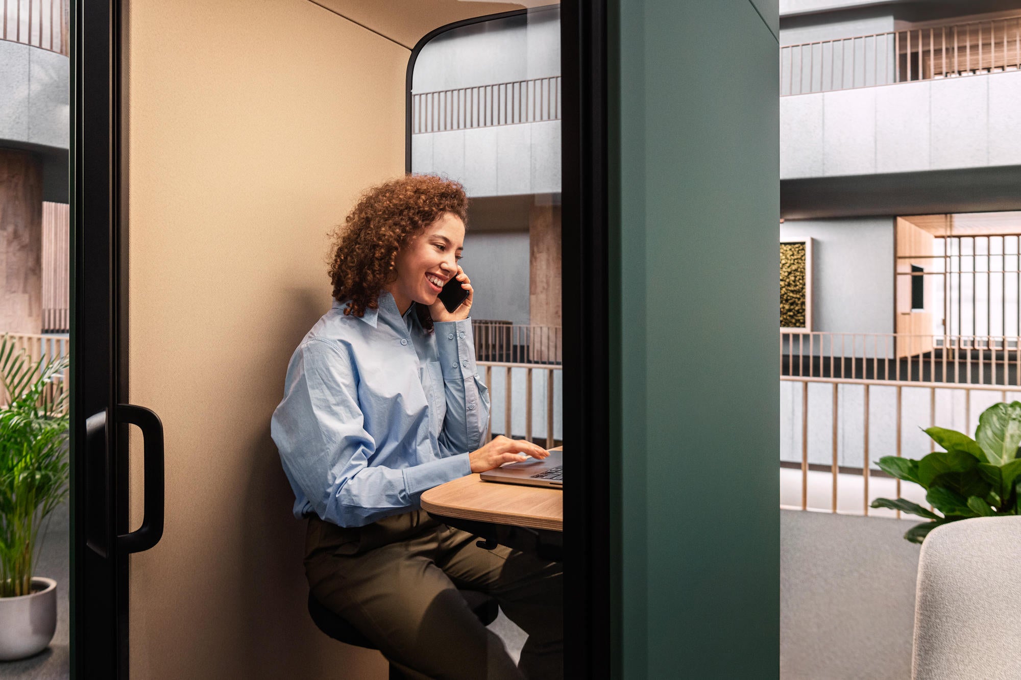 Nahaufnahme von Frau in Framery One Compact waehrend Telefongespraech