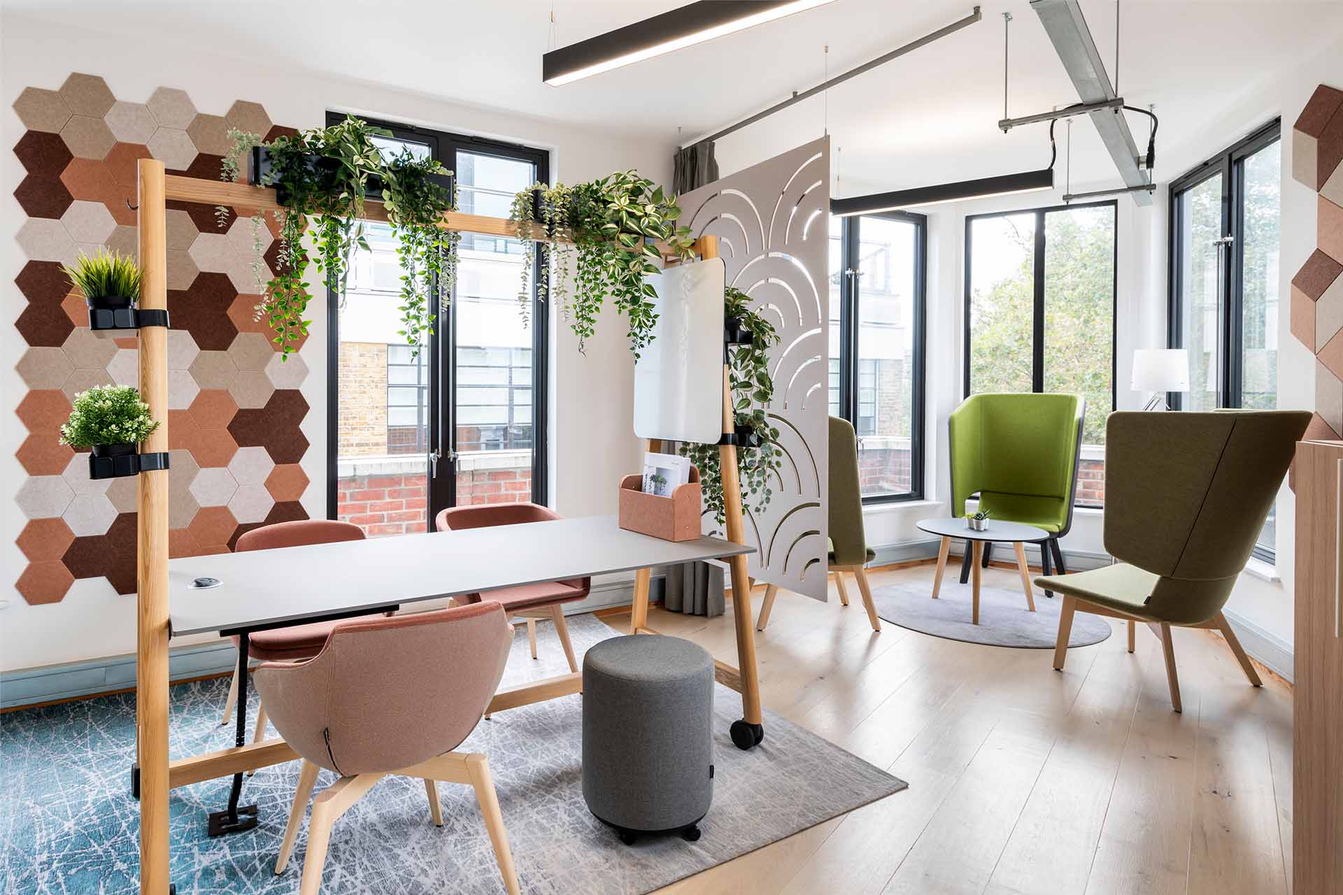 Moderner Besprechungs- und Arbeitsbereich mit nachhaltigen Materialien, ergonomischen Sitzmöbeln und flexiblen Trennelementen, dekoriert mit Pflanzen für eine inspirierende und einladende Atmosphäre, präsentiert von Kibemo
