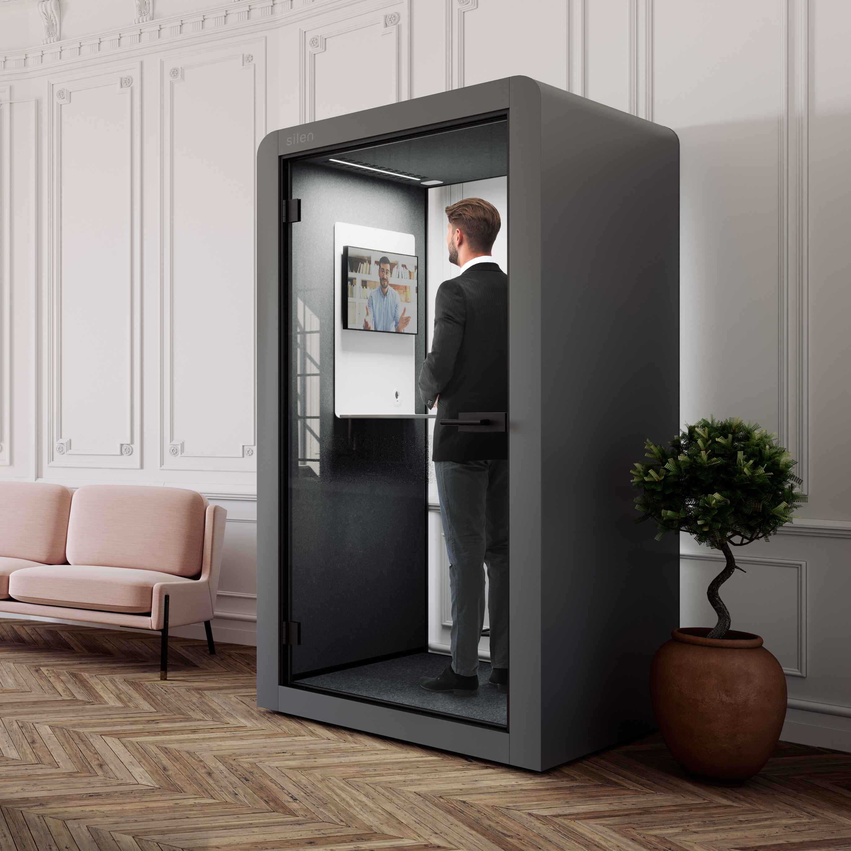 Innenansicht der Silen Space Telefonkabine Maxi mit Tisch, Polstersitz und Belueftung – komfortabler Arbeitsplatz mit Schallschutz fuer effizientes Arbeiten im Buero