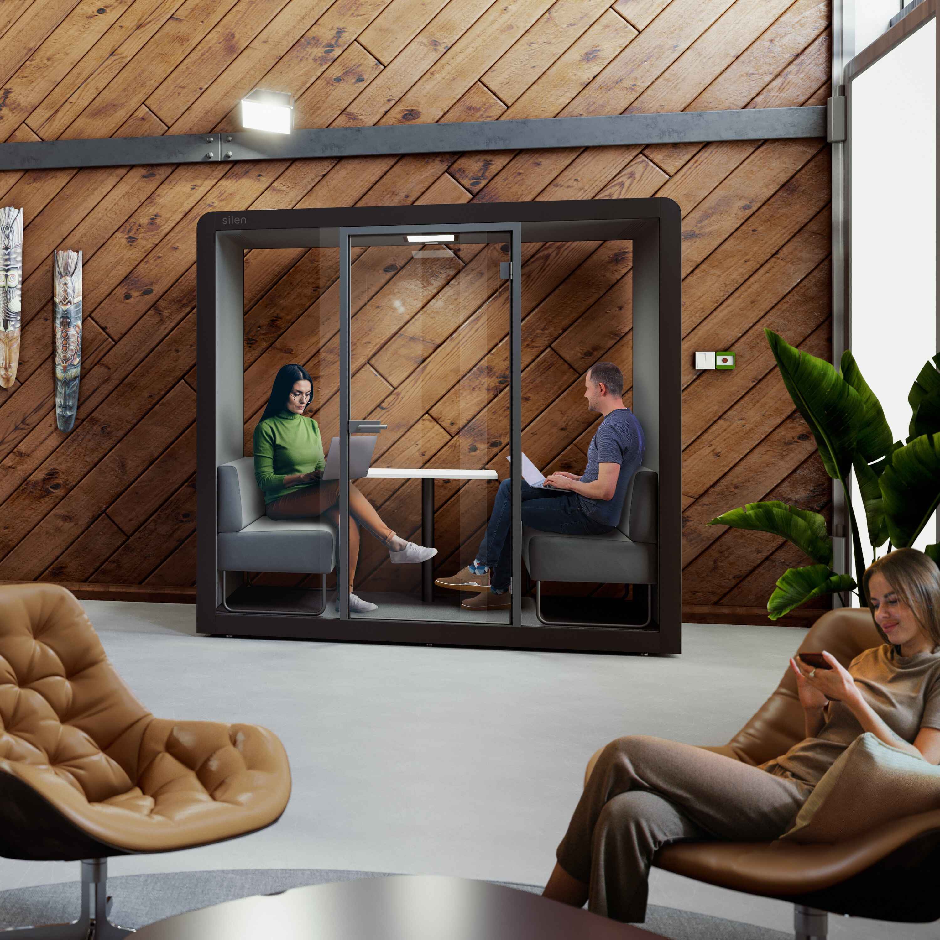 Zwei Personen in der Silen Space Buerobox beim Gespraech – kompakte Schallschutzkabine mit Sitzbaenken und Tisch fuer effiziente Teamarbeit im Buero