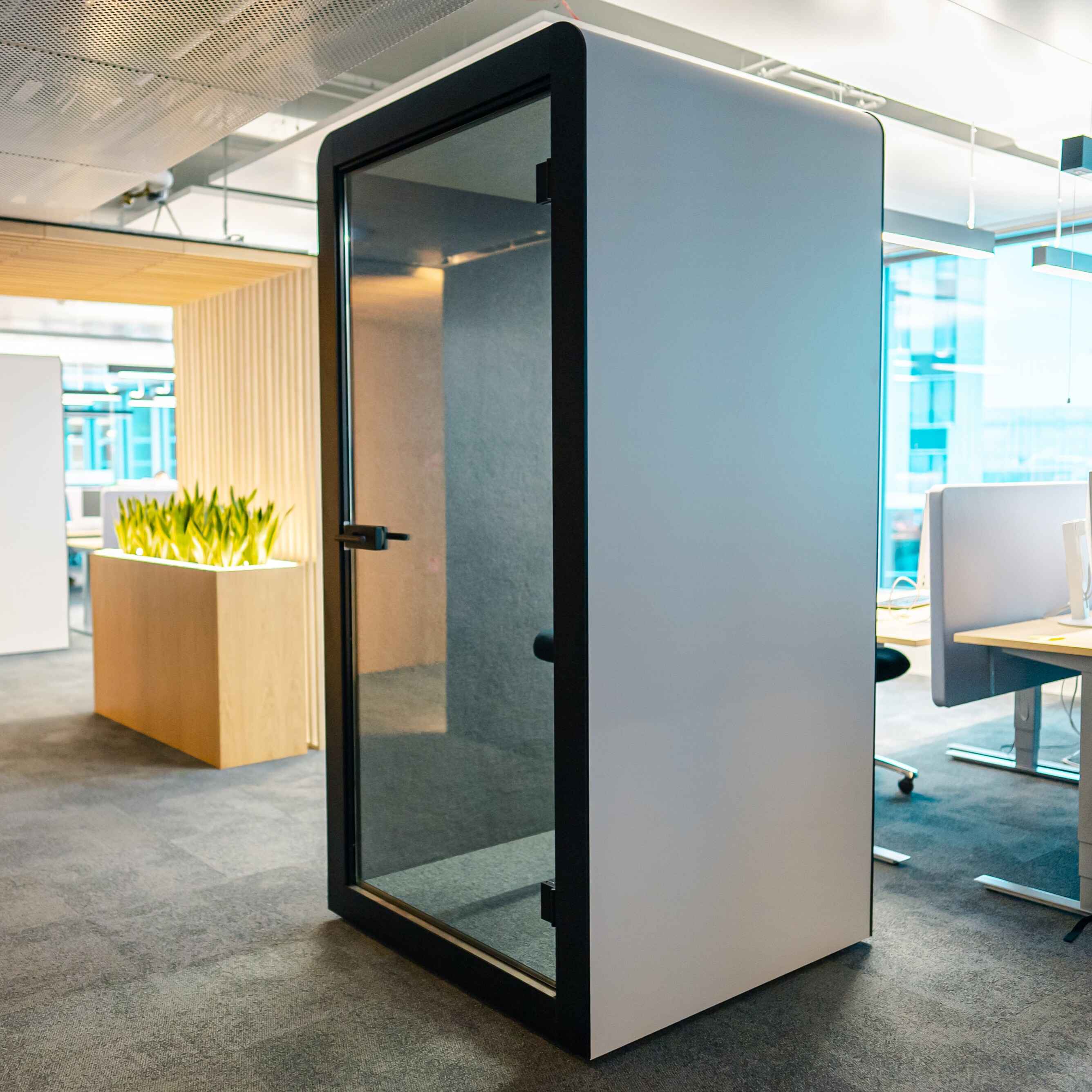 Silen Space Telefonkabine in offener Buerozone mit Glasfront und schallisoliertem Innenraum – ideale Akustikloesung fuer vertrauliche Telefonate und konzentriertes Arbeiten