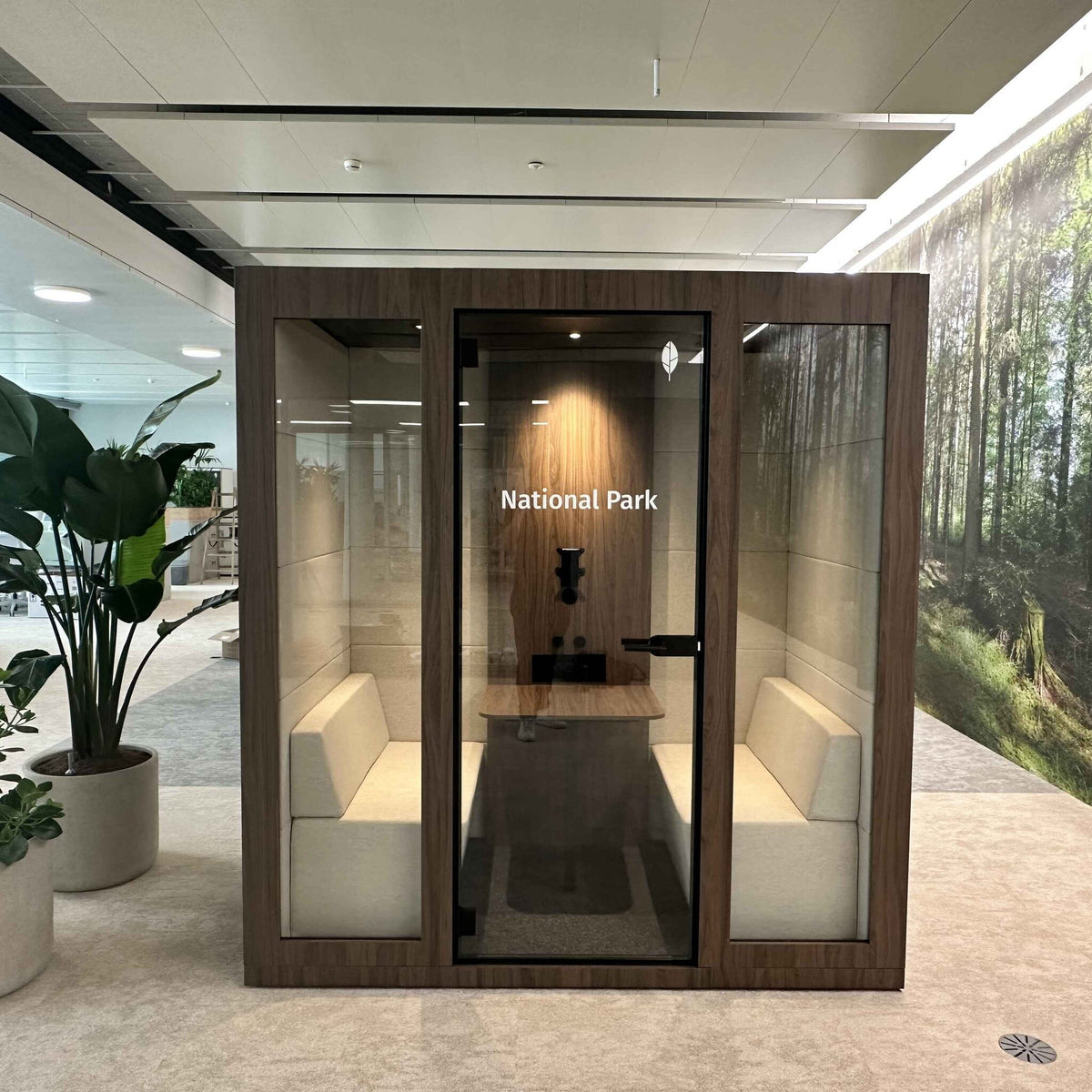 Silent Room M Besprechungsbox in Holzoptik mit Glasfront und gepolsterten Sitzbaenken – stilvolle Raum-in-Raum Loesung fuer vertrauliche Meetings und konzentrierte Teamarbeit im Buero