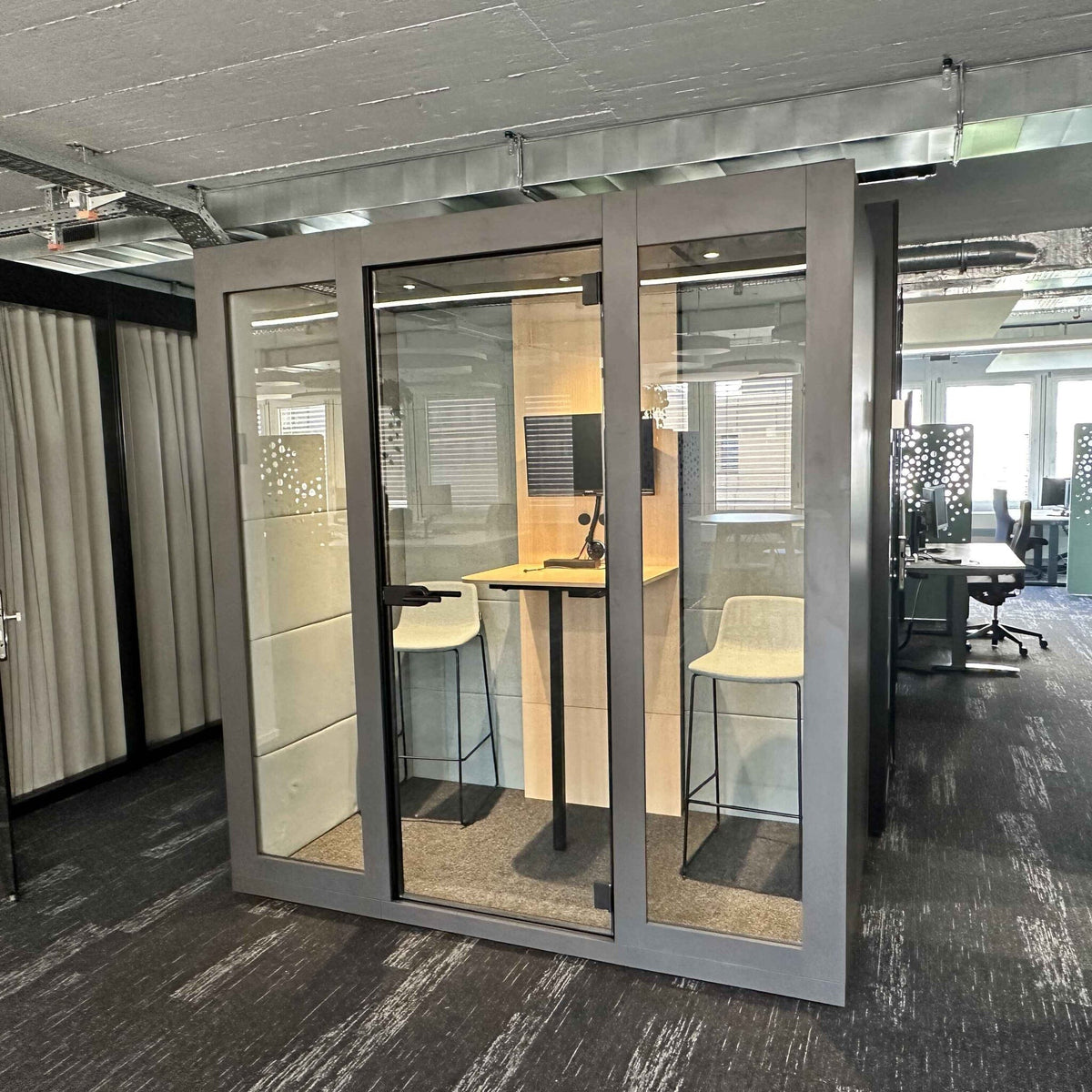 Besprechungsbox Silent Room M mit zwei Sitzbaenken, Tisch und Glaswaenden – schallisolierte Kabine fuer vertrauliche Gespraeche und fokussierte Zusammenarbeit im Buero.