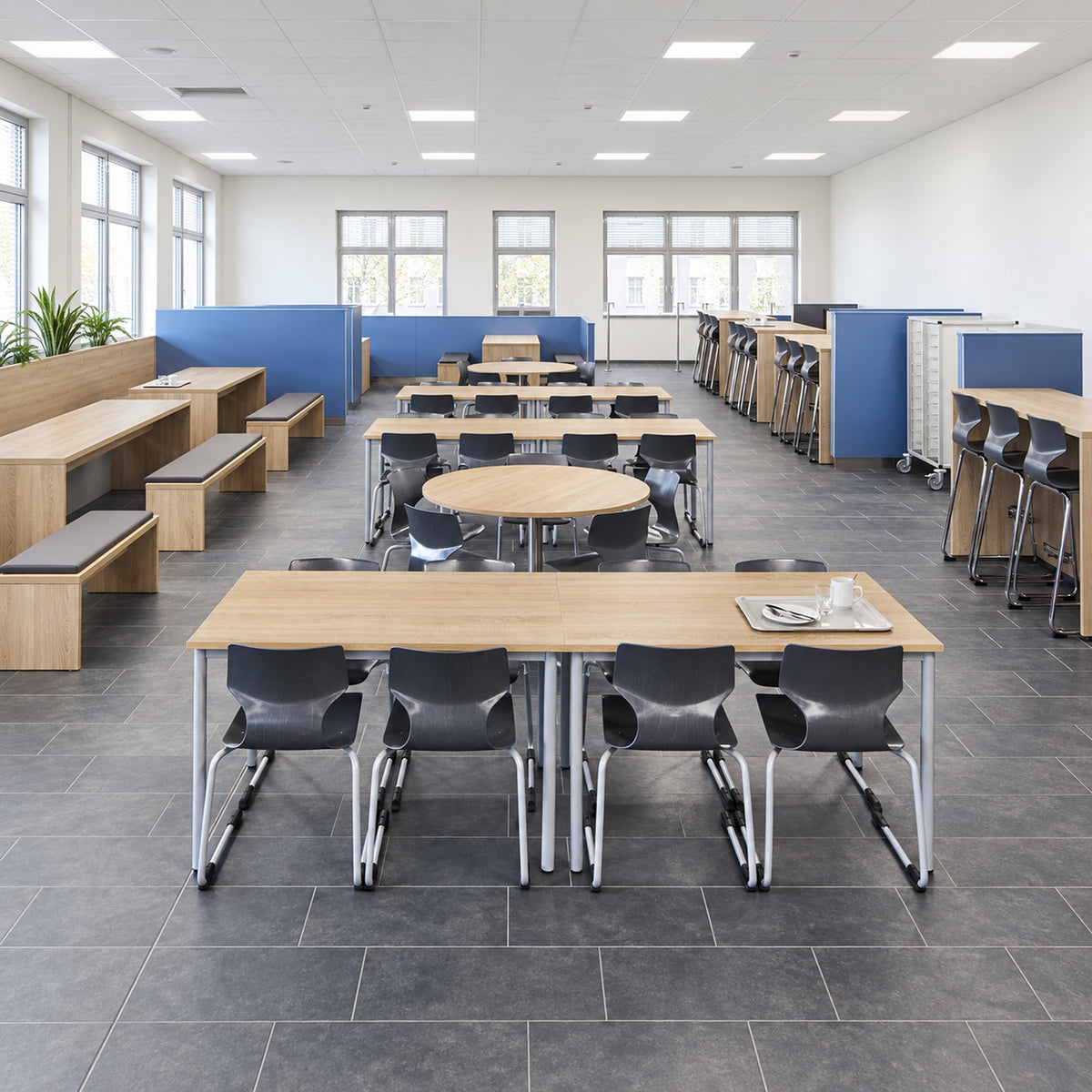 Schultisch 2er mitwachsend höhenverstellbar für Schule & Seminar in einem hellen Schulraum mit schwarzen Stühlen.