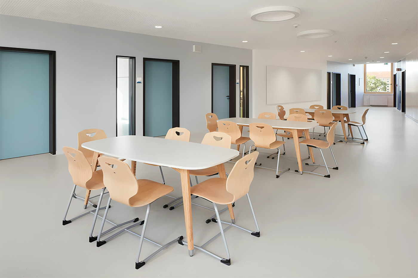 Moderne Schulmoebel im Einsatz, mit funktionalen Tischen und ergonomischen Stuehlen, die eine ansprechende und produktive Lernumgebung schaffen, praesentiert von Kibemo