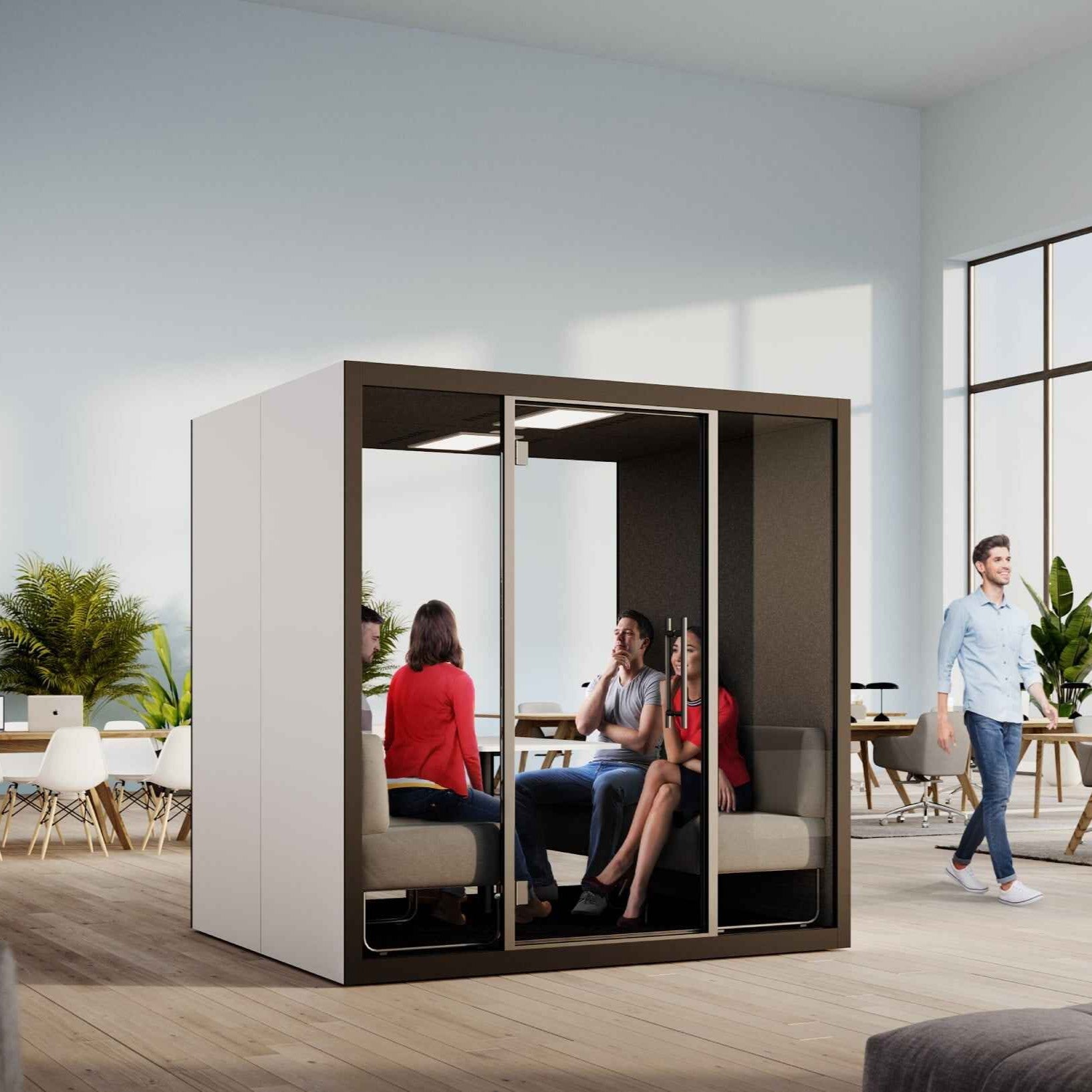 Vier Personen im Gespraech in der Chatbox Quattro Akustikbox – schallreduzierte Meetingkabine mit Tisch und gepolsterten Sitzbaenken fuer produktive Teamarbeit im Buero