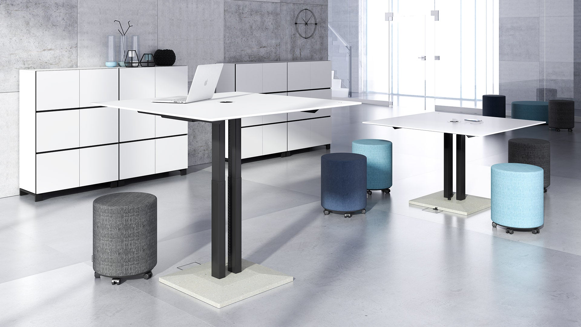 Moderne Büroumgebung mit elektrisch höhenverstellbaren Tischen und passenden Bürohockern