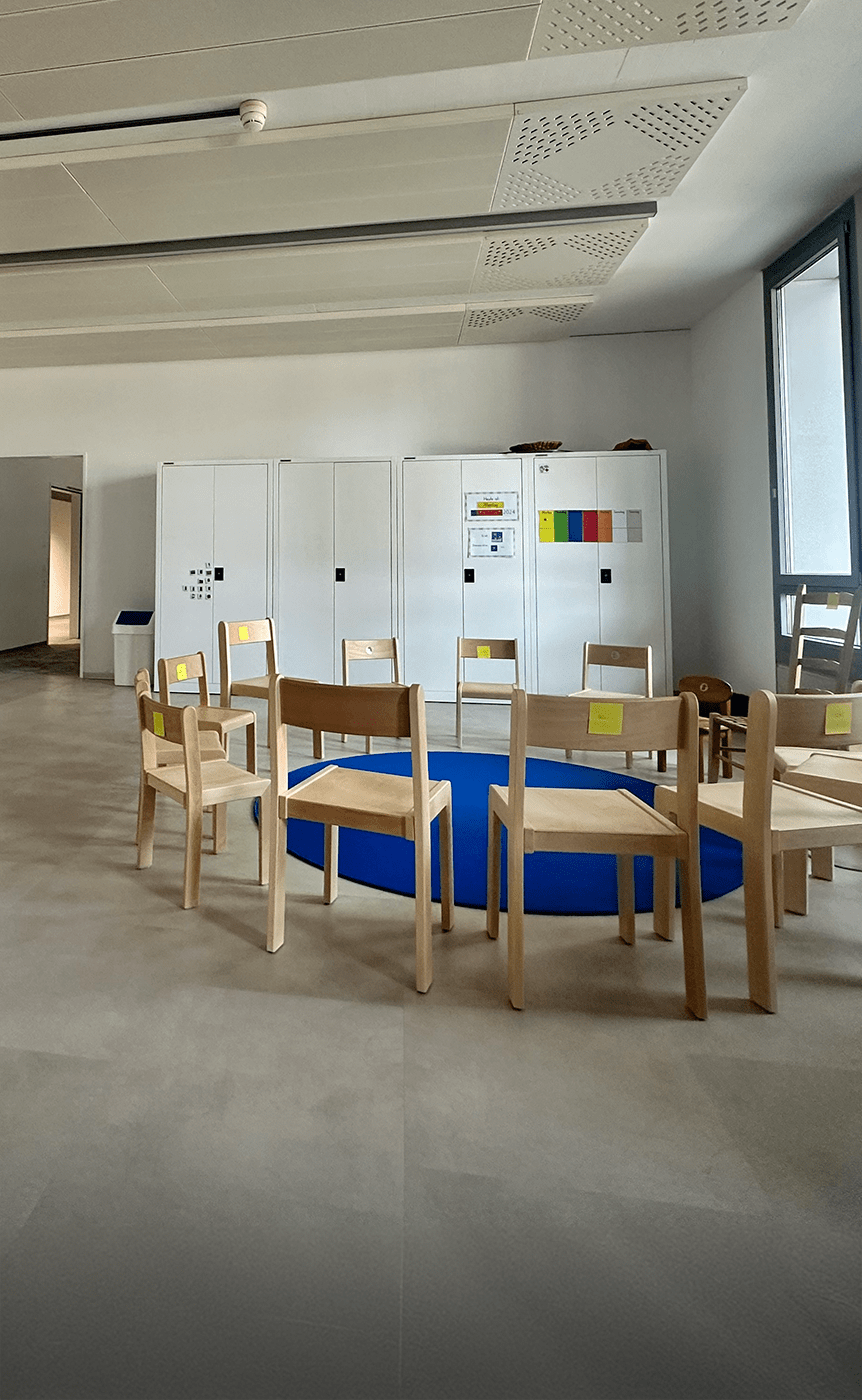 Heller Klassenraum mit modernen Schulmoebeln, darunter ergonomische Stuehle, robuste Tische und praktische Aufbewahrungsmoeglichkeiten, ideal fuer eine funktionale und motivierende Lernumgebung, praesentiert von Kibemo