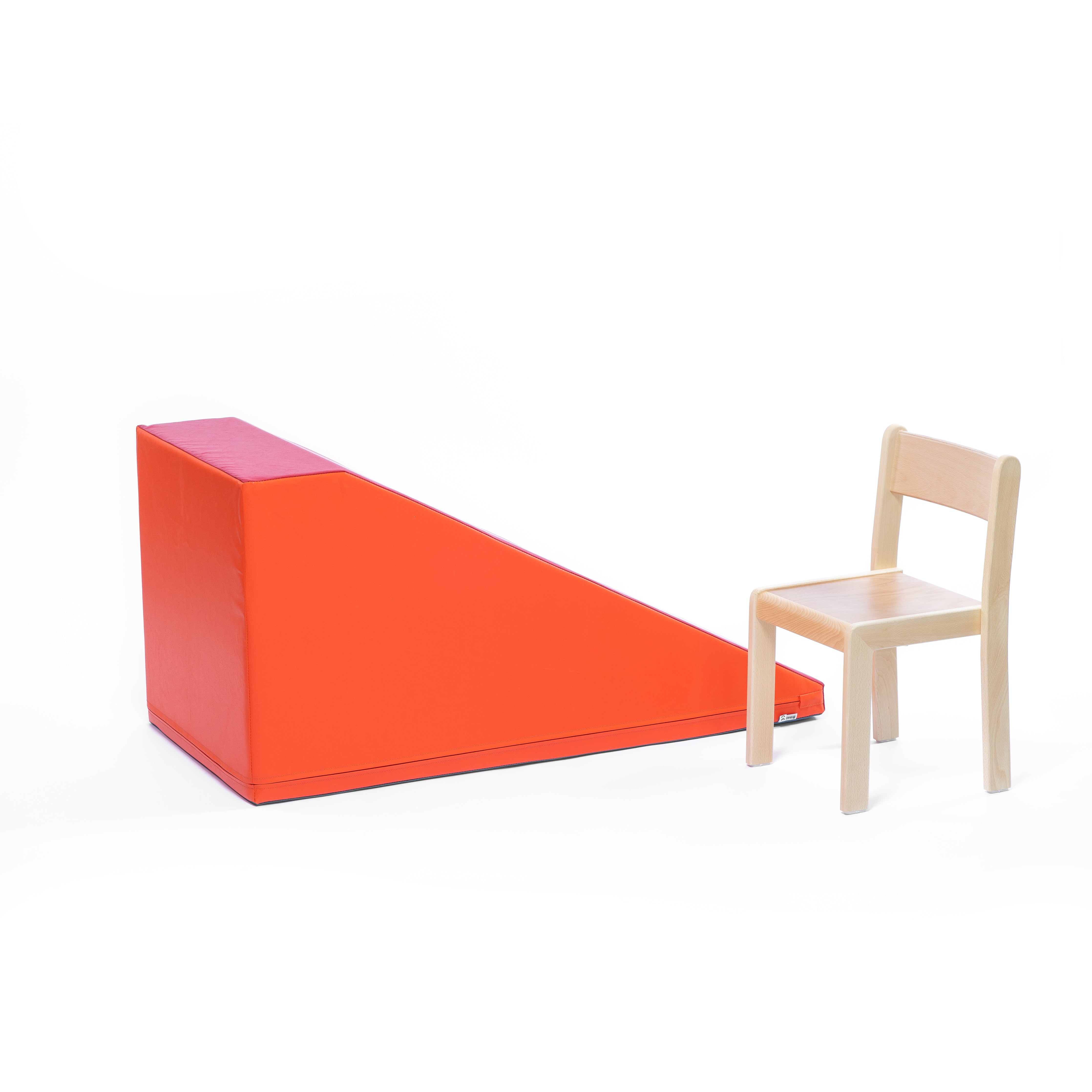Softbausteine Bewegungslandschaft Element in orange für Kita und Kindergarten mit Kinderstuhl im Vordergrund