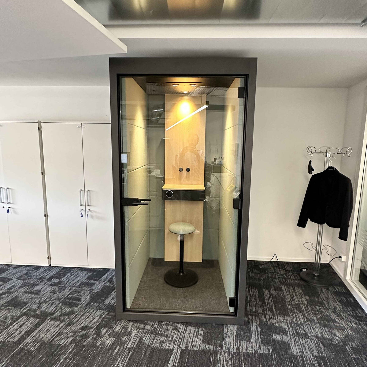 Telefonkabine Silent Room S mit weissem Rahmen, Glasfront und integrierter Beleuchtung – ideale Schallschutzloesung fuer ungestoerte Telefonate und fokussiertes Arbeiten im Buero