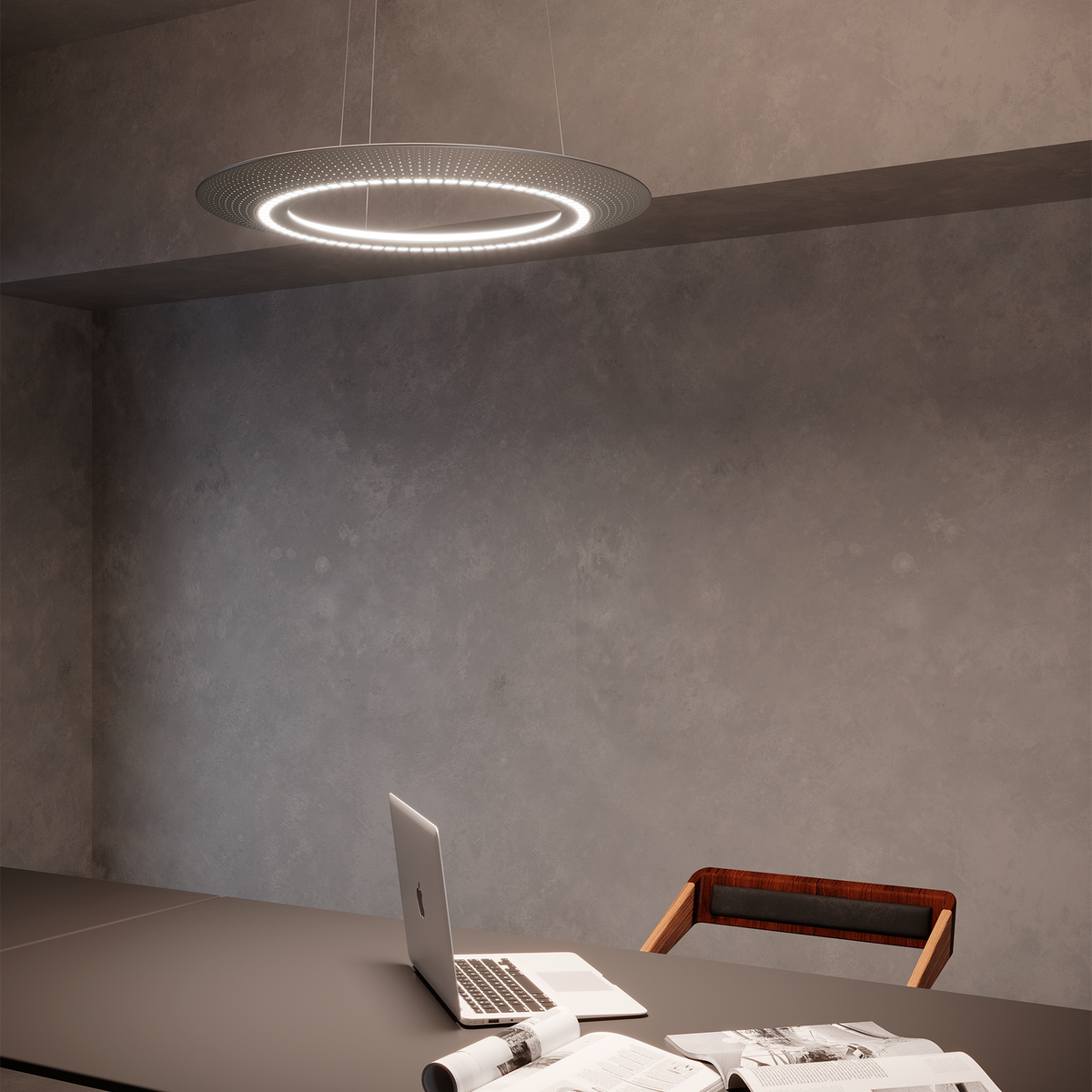 Leuchtende Zumtobel AMBITUS Ring-Pendelleuchte über einem Büro-Schreibtisch mit Laptop und Unterlagen.